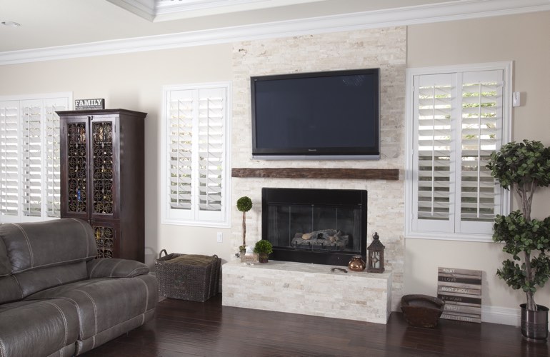 White plantation shutters in a Dallas living room with plank hardwood floors.